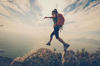 Woman hiker hiking on mountain peak