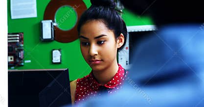 Schoolgirl studying on computer in classroom