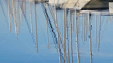 At dawn, in the water reflect the masts of white chic beautiful yachts. Clear summer morning in the marina, on the sea