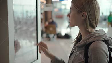 Beautiful attractive woman in airport terminal. Ordering food via self-service machine at Mcdonald`s
