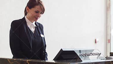 Positive female receptionist typing on computer