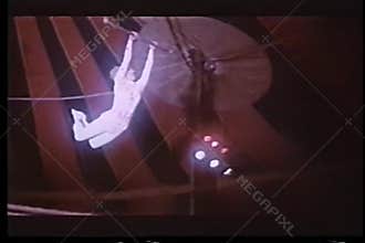 Two trapeze artists switching bars in midair