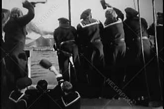 Rear view of sailors waving to submarine