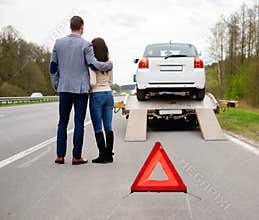 Couple and broken car on a highway