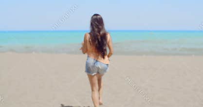 Happy Woman at the Beach Waving at the Camera