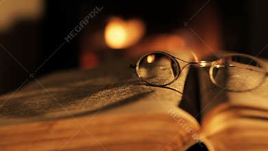 Old book and glasses in front of the fireplace.