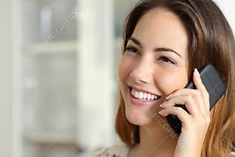 Woman talking on the mobile phone at home