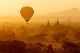 Air balloons over Buddhist temples at sunrise.