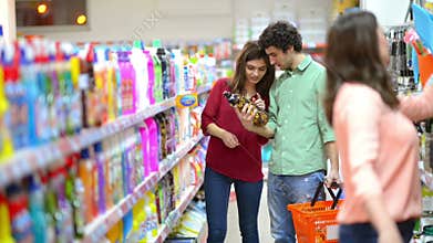Customers choosing cleaning products in supermarket