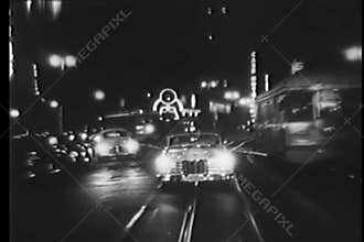Vintage car driving on cable car tracks at night