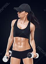 Fitness sporty woman in training pumping up muscles with dumbbells