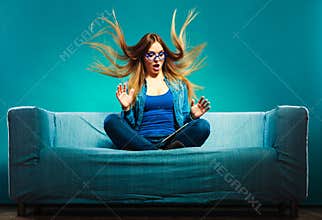 Girl hair blowing with tablet on couch