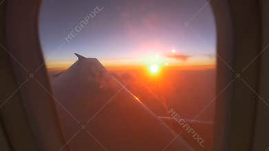 Airplane window view at sunset