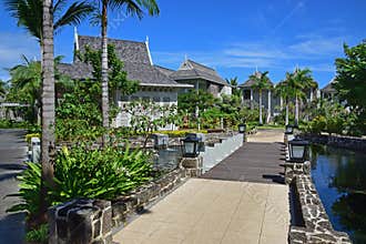 Beautiful upscale resort hotel with small wooden bridge connecting to the villas with abundant trees around