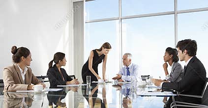 Group Of Business People Having Board Meeting Around Glass Table