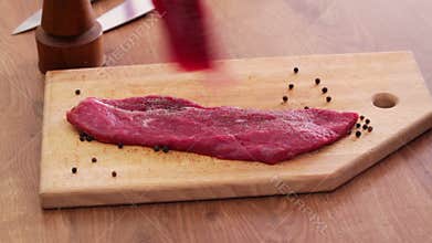 Beef steak slices seasoning with salt- closeup