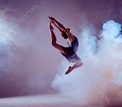 Beautiful young ballet dancer jumping on a lilac