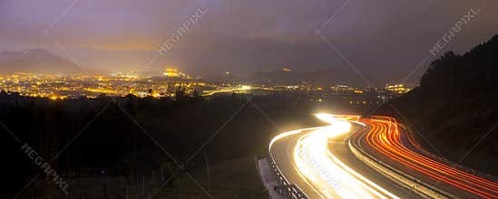 Car lights at night on the road going to the city
