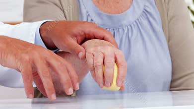 Doctor showing patient how to exercise injured hand
