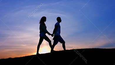 Lovers walk holding by hands.