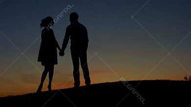 In love couple admiring the sunset.