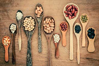 Assortment of beans and lentils in wooden spoon on teak wood background. mung bean, groundnut, soybean, red kidney bean , black b