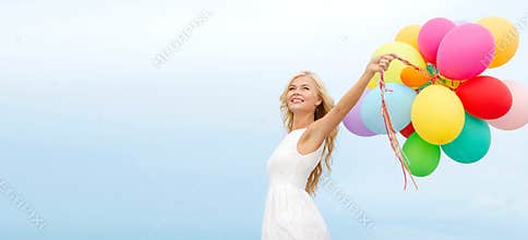 Smiling woman with colorful balloons outside