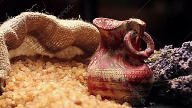 Brown sugar in gunny sack and an ancient pottery vessel, rotating