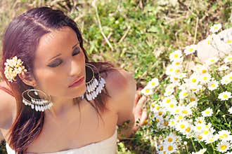 Female purity. Beautiful woman with daisies on the lawn. Closed eyes