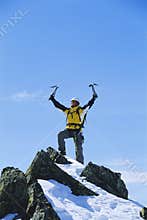 Young man celebrating reaching the top of mountain