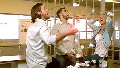 Creative team throwing crumpled balls of paper