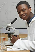 Portrait Of Pupil Using Microscope In Science Lesson