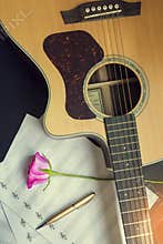 Guitar with pen and rose on the note book,vintage filter