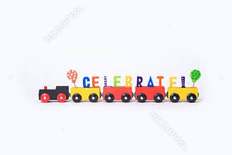 Toy train with colorful letters on top arranged in word celebrate