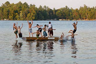 Group of kids jumping into Lake