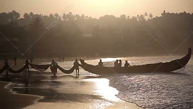 Indian fishermen in silhouette at sunrise