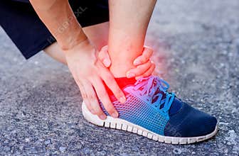 Runner touching painful twisted or broken ankle. Athlete runner training accident. Sport running ankle sprain