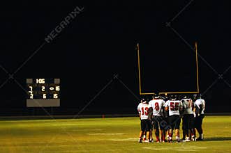 Football huddle at night game