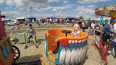 Baby girl having fun in a fair country carousel