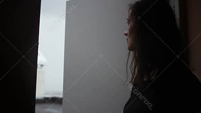 Young woman opens a door from darkness to light