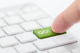 Hand pushing go green button