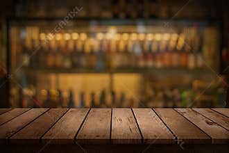Wood table with a view of blurred beverages bar backdrop