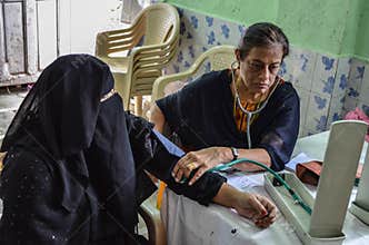 A female doctor checking the blood pressure of a patient during a medical camp