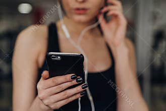 Beautiful girl with a phone in the gym
