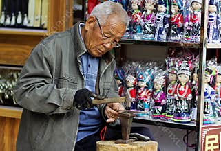 Elderly craftsman making handmade silverware at Tianlong Tunbao, Guizhou