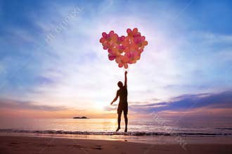 Love concept, man flying with heart from balloons