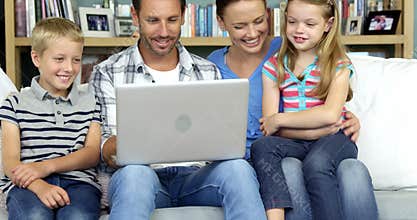 A happy family enjoying a moment with a computer