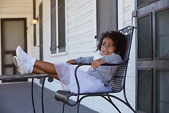 Kid girl sitting in the park house porch