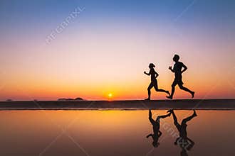 Workout, silhouettes of two runners on the beach