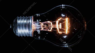 Edison lamp light bulb blinking over black, macro view